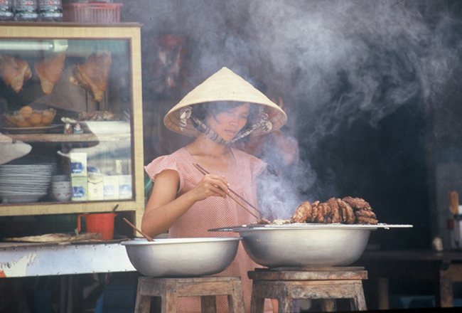 Lady cooking street food in Vietnam