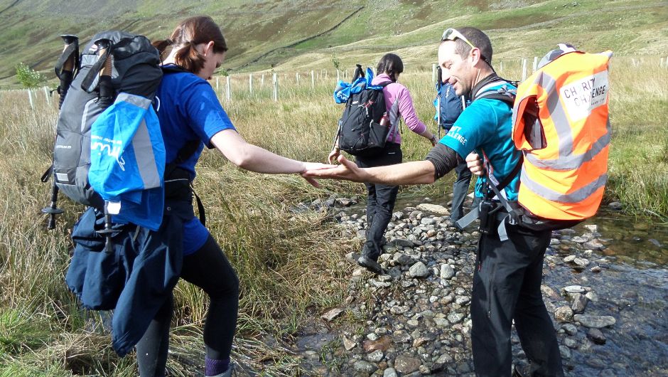 charity challenge leaders helping participants hiking