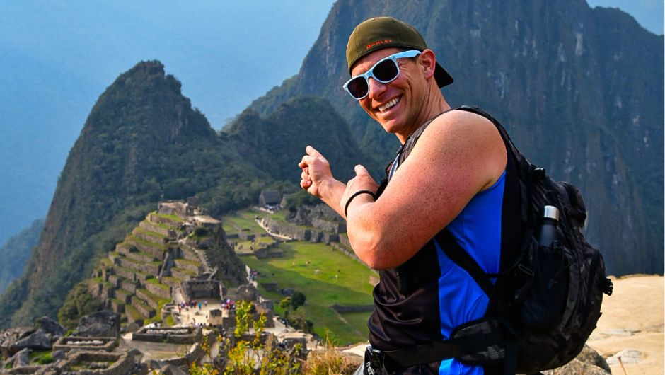 A trekker standing in front of Machu Pichu, Peru. A UNESCO World Heritage Site and a new wonder of the world