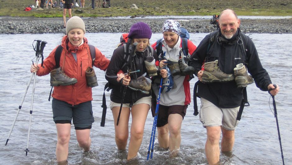 a group of trekkers crossing glacier rivers in iceland