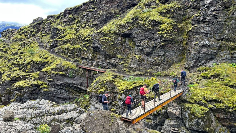 a group of trekkers crossing a bridge in Iceland