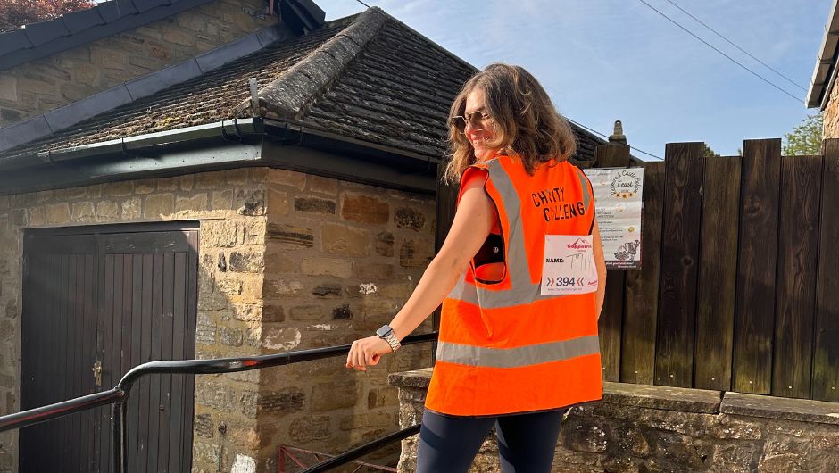 Charity Challenge Account Manager Tilly Sawyer wearing an orange hi vis at a CoppaFeel challenge event