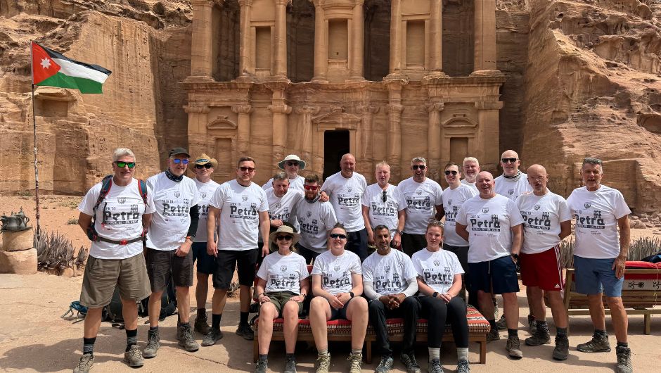 The Albion Foundation Trek to Petra challengers in front of the treasury with a charity challenge and albion foundation flag