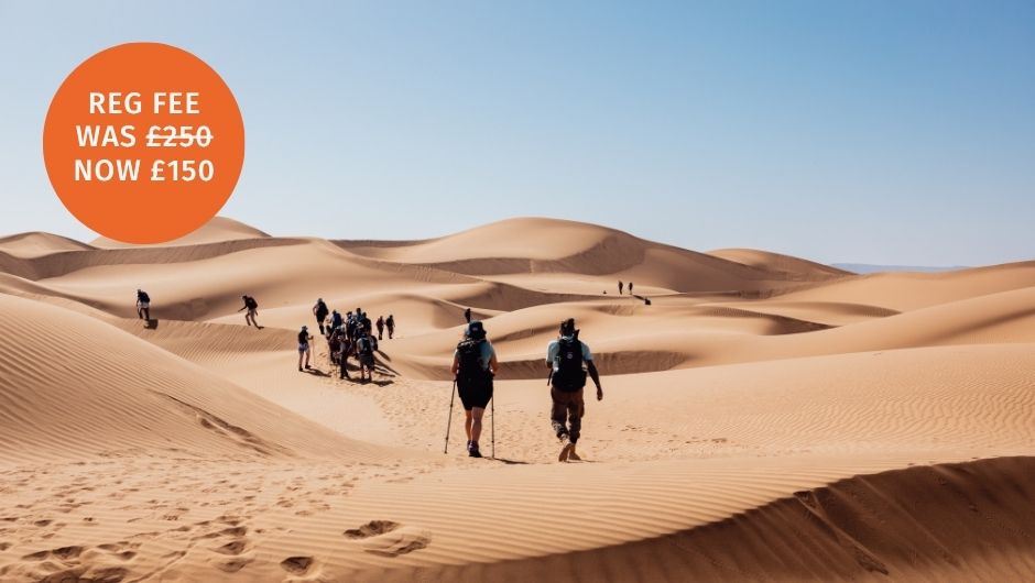 A group of trekkers walking through the sand dunes in the Sahara Desert, Morocco