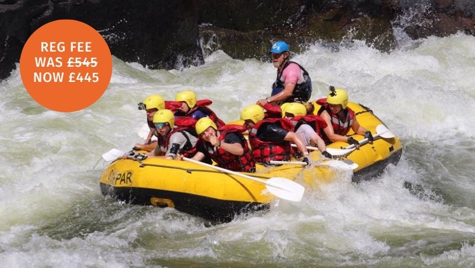 a group of paddlers white water rafting the Zambezi River in a yellow raft