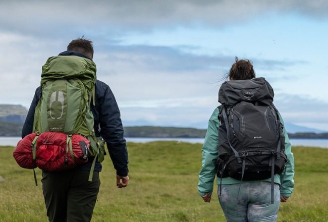 two trekkers hiking with their full packed daypacks