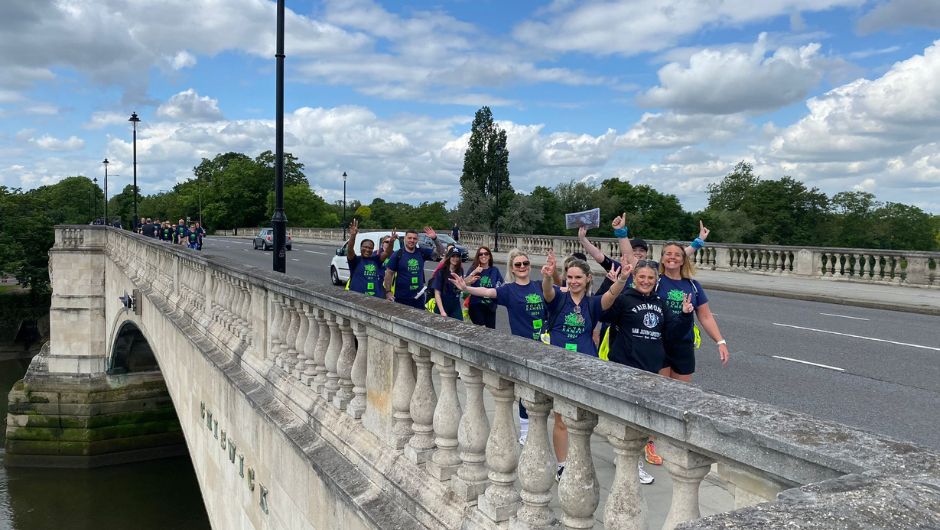celebrating challengers walking across a bridge on the thames footpath challenge