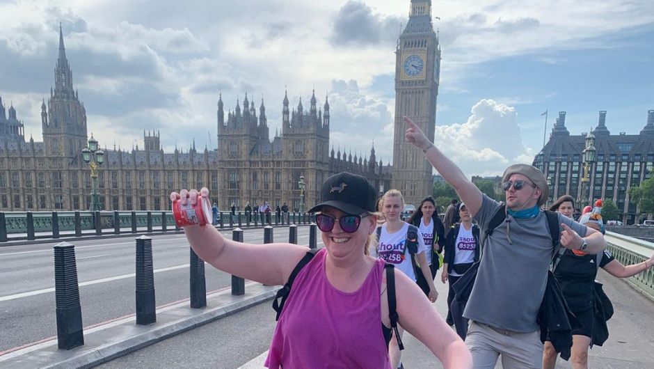 happy smiling challengers walking part the houses of parliament on the thames footpath challenge