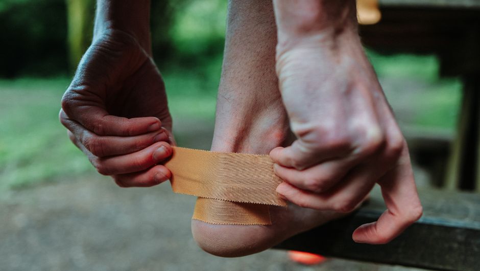 man using SPORTTAPE kinesiology tape to prevent blisters, a common complaint and injury on challenges