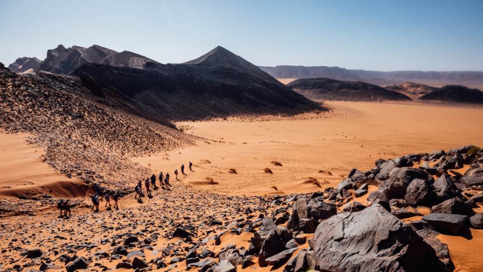 Challengers trekking across the rocky and sandy sahara desert with charity challenge