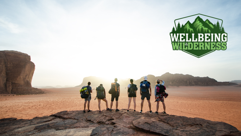 A group of trekkers in Jordan looking out across the Wadi Rum desert in the morning sunshine