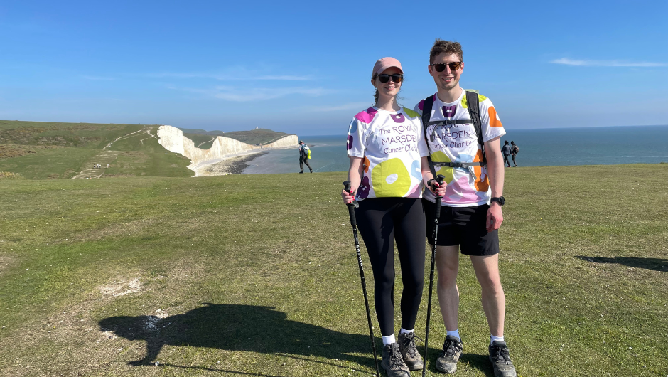 Two people smiling on the Seven Sisters Cliffs during a South Downs Challenge trek.