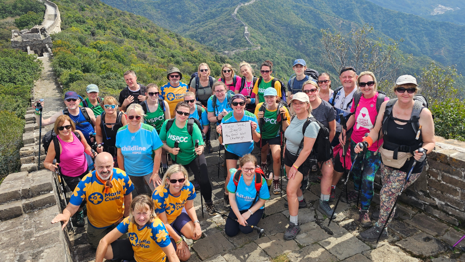 A group of people smiling on a section of the great wall of china
