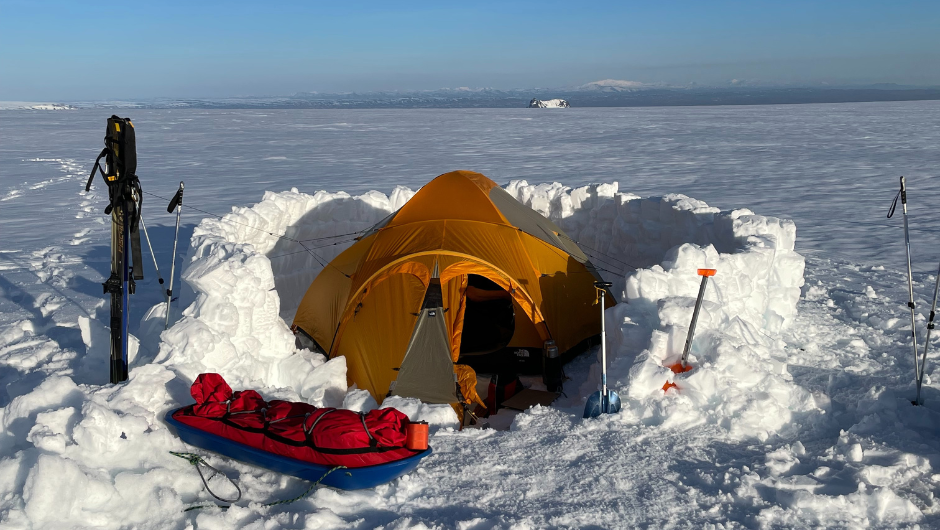 An orange tent set up in a dug out area of glacier on the Icelandic Glacier Trek.