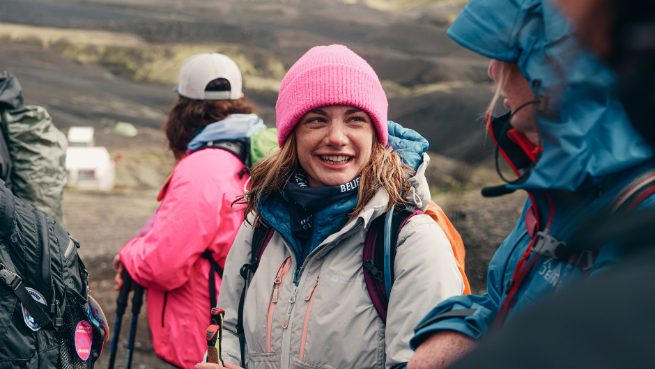 A smiling trekker wearing warm hiking gear and a charity challenge neck buff during the Icelandic Lava Trek challenge.