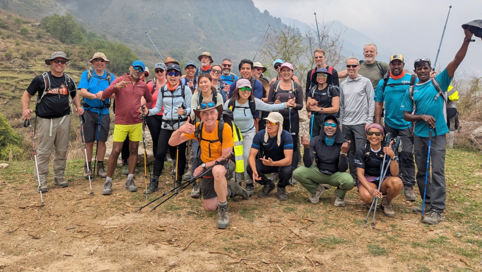 A group of trekkers. wearing hiking gear, smiling for the camera in the Indian Himalayas.