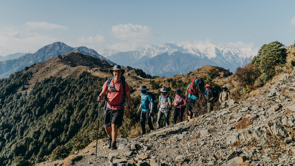 a line of trekkers hiking along a rocky mountain ridge in the indian himalayas