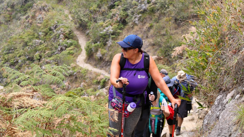 A group of people trekking together on an uphill section of a Charity Challenge in the Indian Himalayas.