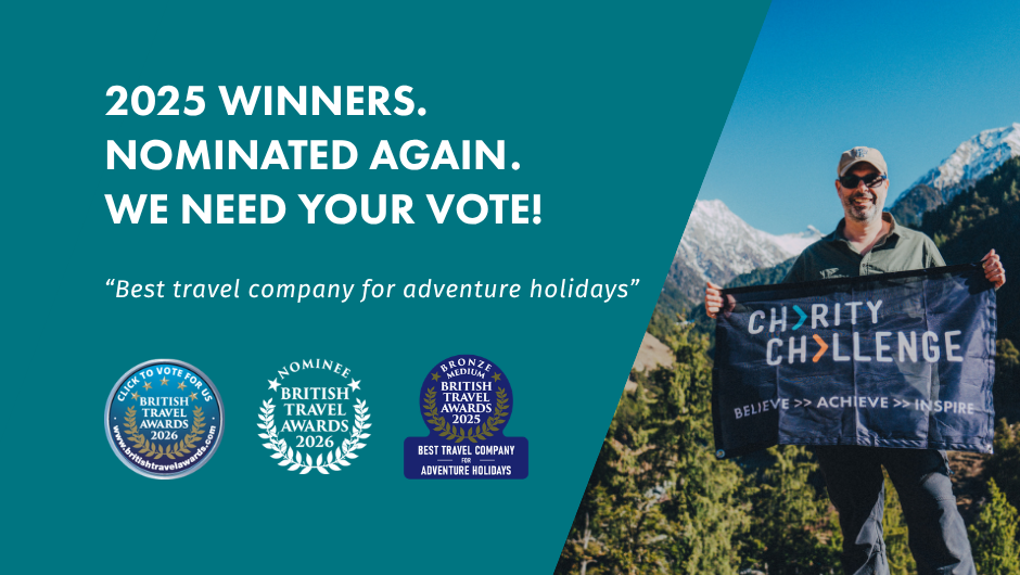 BRITISH TRAVEL AWARDS 2026 - Simon Albert, Charity Challenge founder holding a Charity Challenge flag  in front of the Indian Himalayas