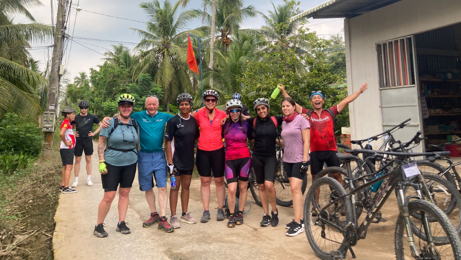 a group of cyclists standing celebrating together in south east asia