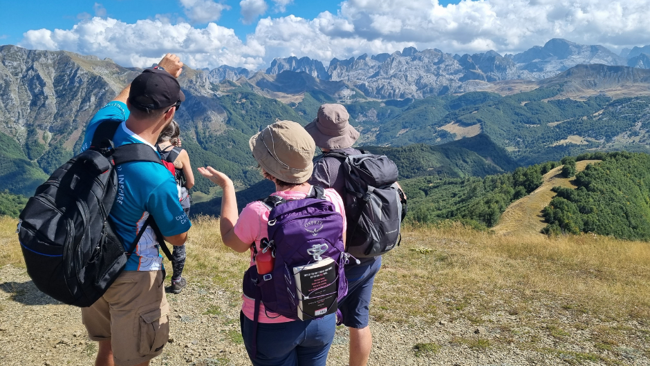 A group of Charity Challenge trekkers looking out towards a green, rugged mountainous view.