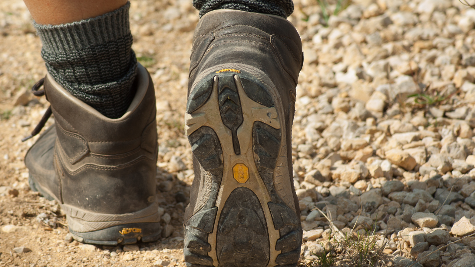 a close up of walking boots walking along a gravel road.