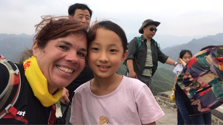 A charity challenge leader taking selfie with a young local in China.