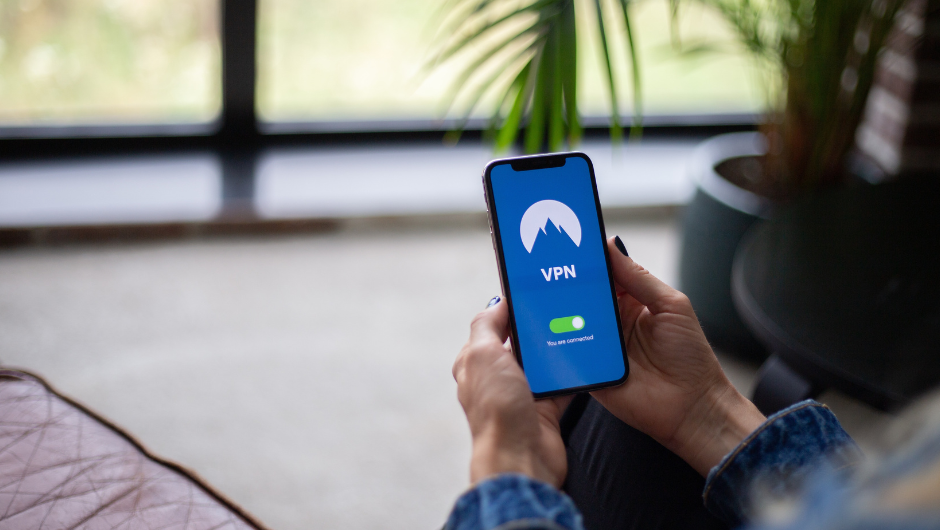 a person holding their phone which has a VPN screen on
