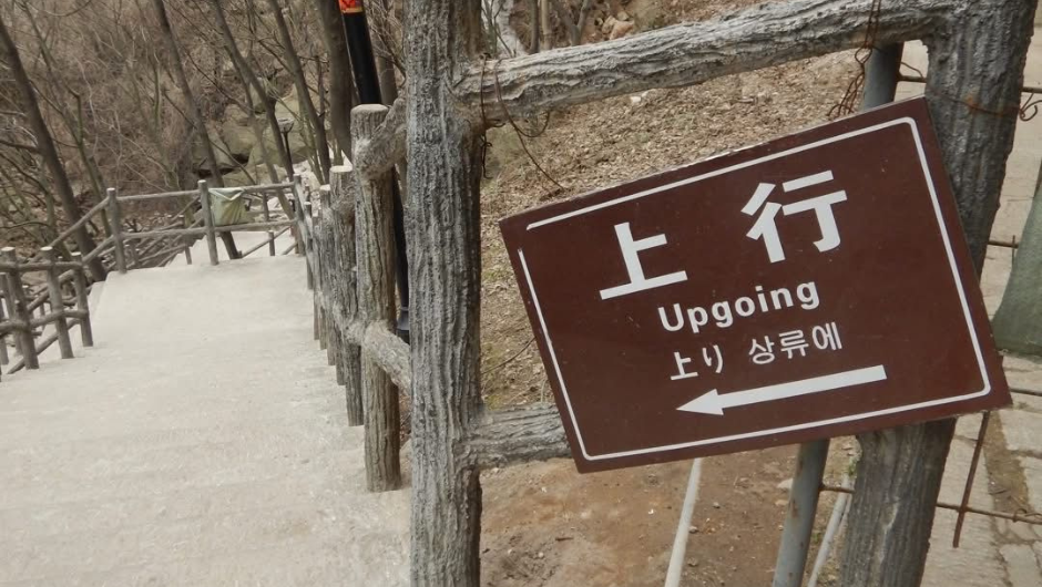 A direction sign saying upgoing on a section of the great wall of china