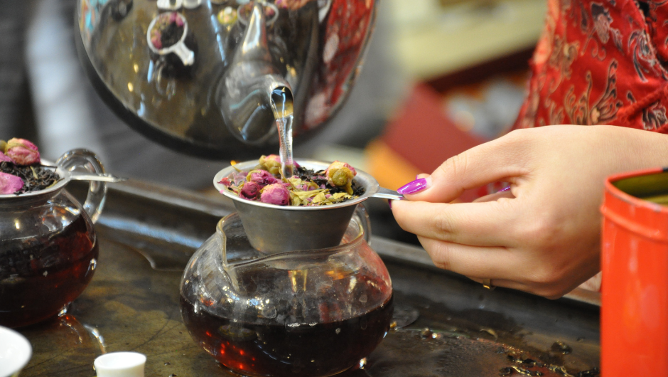 A close up of a woman preparing some traditional chinese tea leaves.