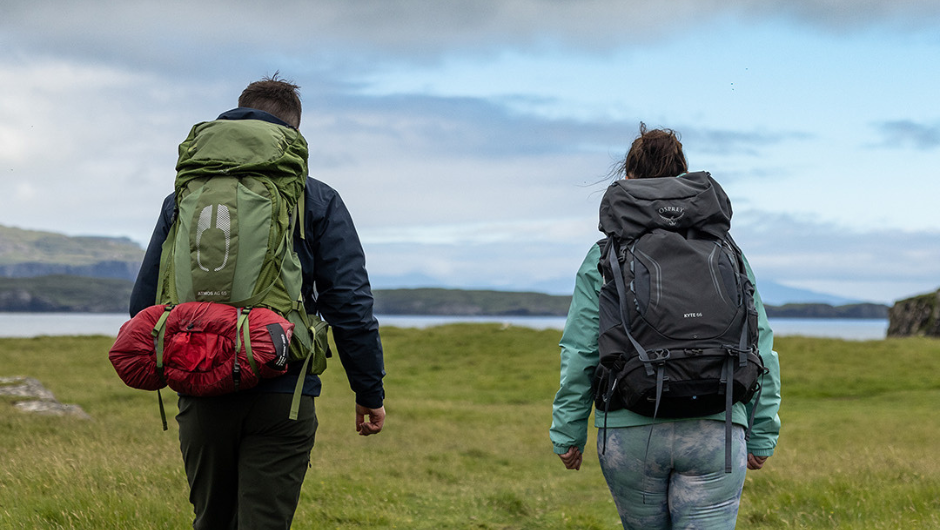 Two people trekking in the UK, wearing daypacks.
