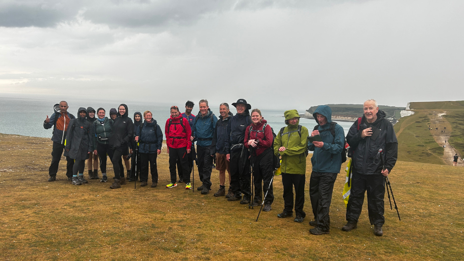 A group of Royal Marsden Cancer Charity supporters on the Seven Sisters Cliffs, during their South Downs trek, dressed in waterproof jackets.