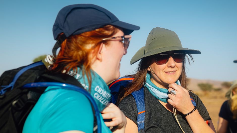 charity challenge trekkers on the sahara desert trek, wearing sun hats, sunglasses and neck buffs to protect themselves from the elements