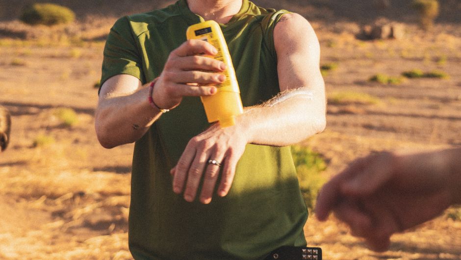 a person applying SPF suncream during their sahara desert trek challenge