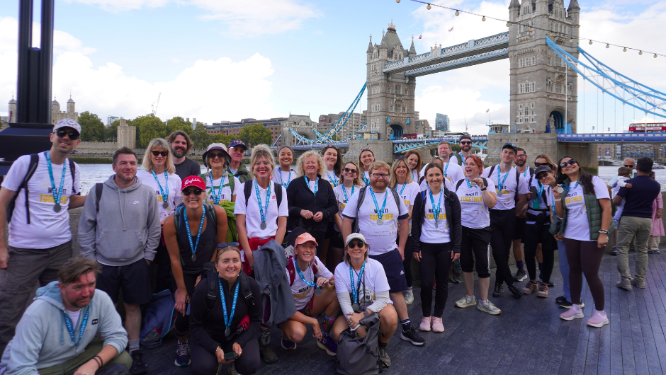 a large group of challengers all wearing medals and smiling for a group photo at the end of their thames footpath challenge