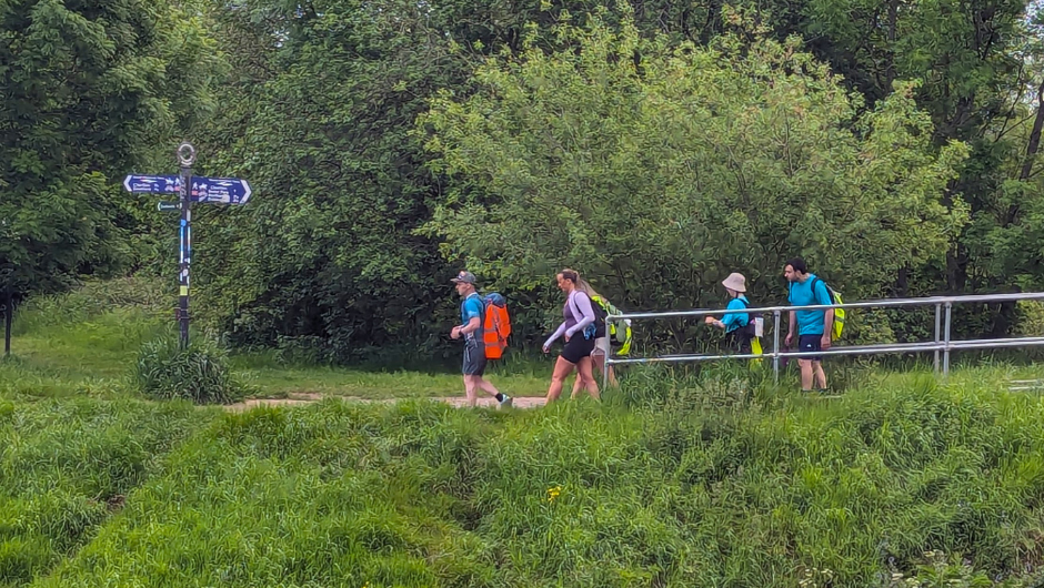 a challenger leader trekking with challenge participants through a woodland section of the manchester canals trek