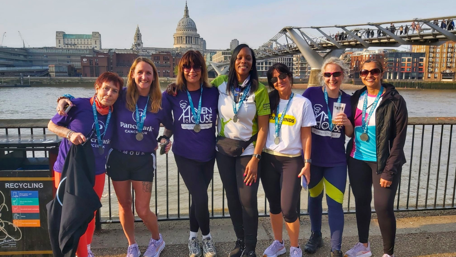 a group of people wearing challenge medals and smiling for a photo at the end of their uk fundraising challenge
