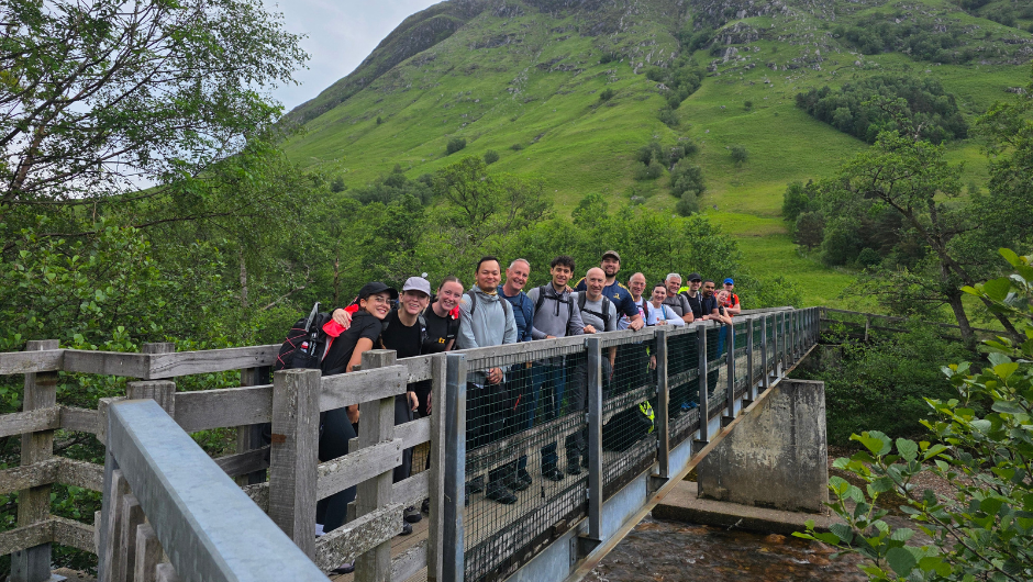 a group of trekkers smiling for a photo along a bridge near scafell pike