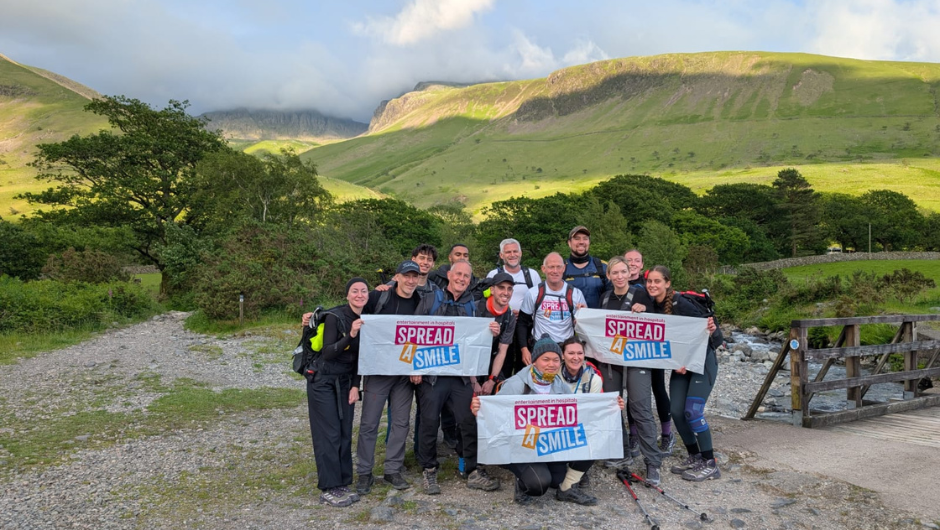 Masthaven Finance National Three Peaks Challengers holding up 'Spread a smile' charity flags during their fundraising trek