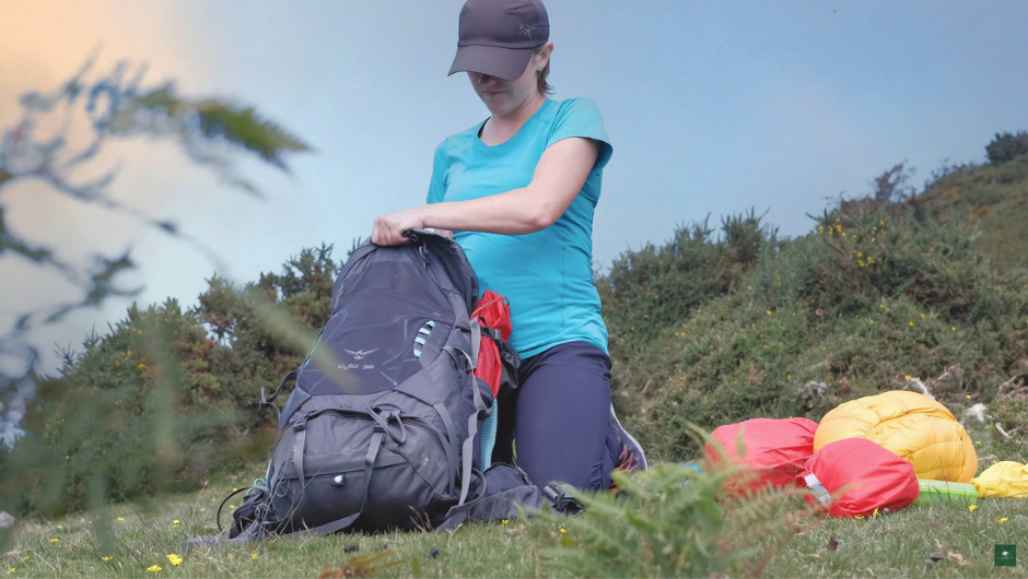 a trekker packing up her daypack