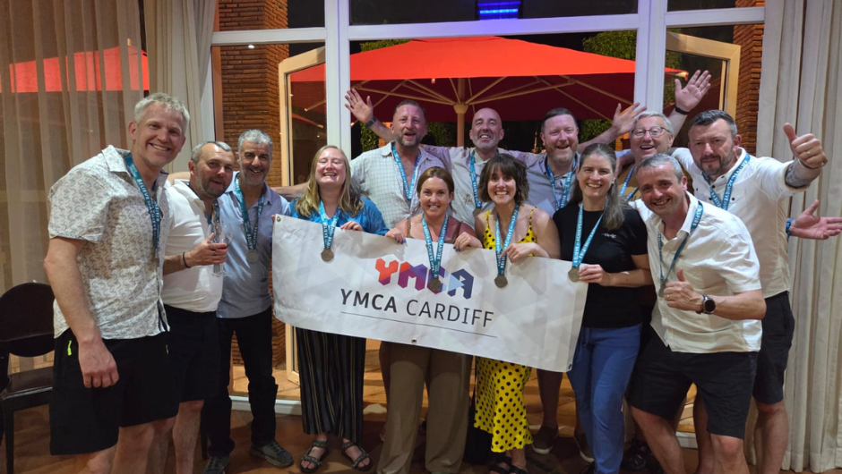 trekkers smiling with their medals and charity banner after completing the ymca cardiff mount toubkal trek
